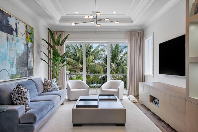 living room featuring crown molding, a tray ceiling, recessed lighting, an inviting chandelier, and wood finished floors