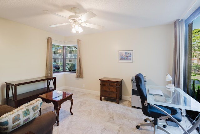 office space featuring baseboards, a ceiling fan, and a wealth of natural light