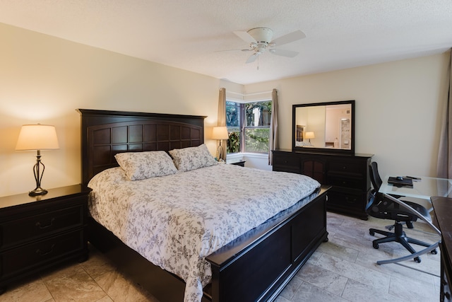 bedroom with ceiling fan and a textured ceiling