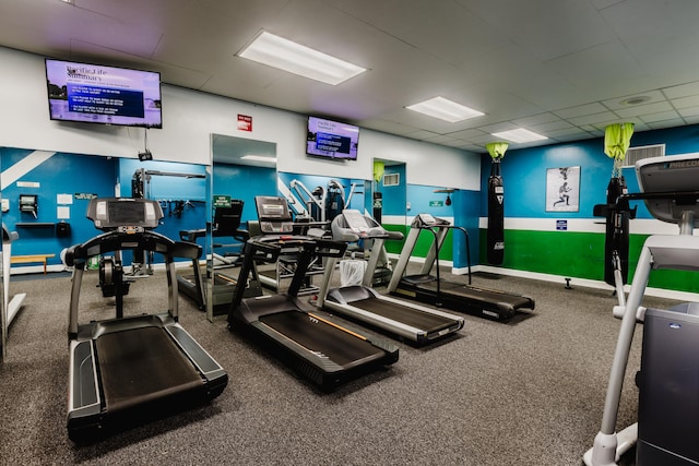 exercise room featuring baseboards and a drop ceiling