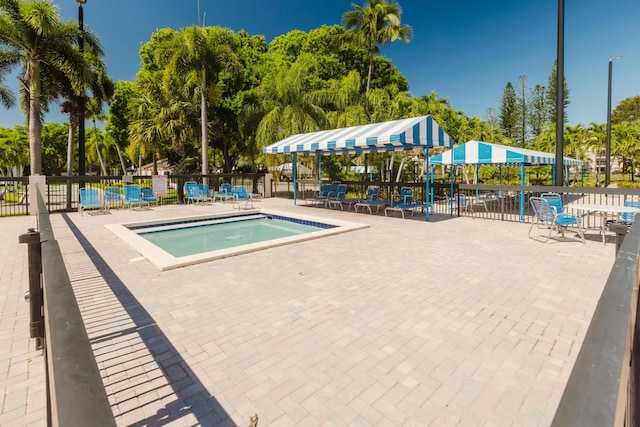 view of swimming pool featuring a patio and fence