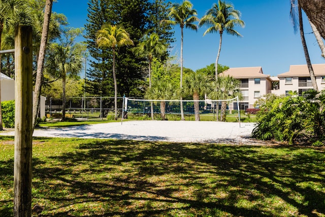 view of home's community with volleyball court, a yard, and fence