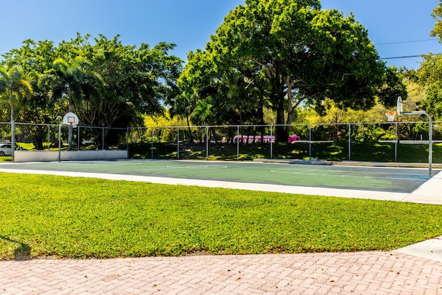 view of basketball court with community basketball court, a lawn, and fence