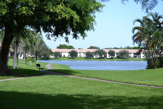 view of community with a yard and a water view