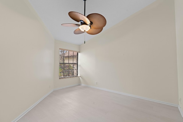 spare room featuring light wood-style floors, a ceiling fan, and baseboards