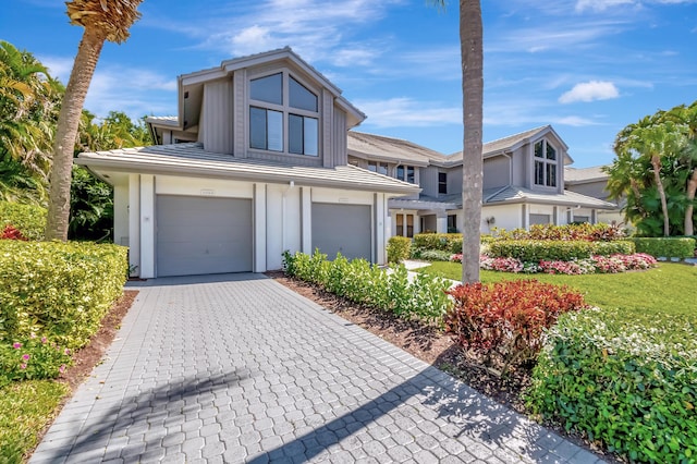 view of front of property featuring decorative driveway, an attached garage, and board and batten siding