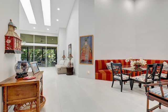 interior space featuring a skylight, a towering ceiling, and recessed lighting