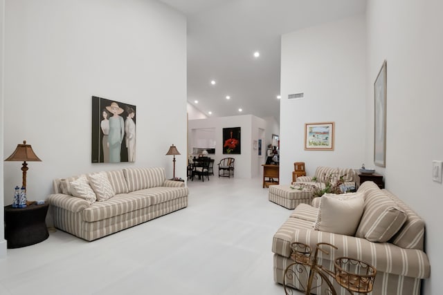 carpeted living area with recessed lighting, visible vents, and a high ceiling