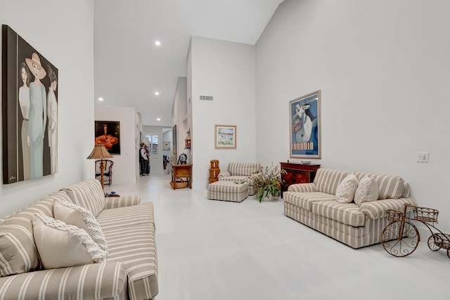 living room with a high ceiling, visible vents, and recessed lighting