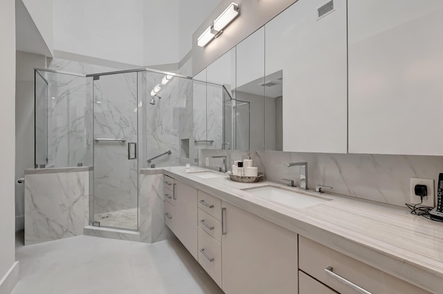 full bathroom featuring a marble finish shower, visible vents, backsplash, and a sink