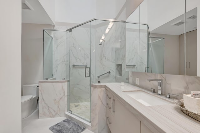 full bath featuring toilet, a marble finish shower, decorative backsplash, and vanity