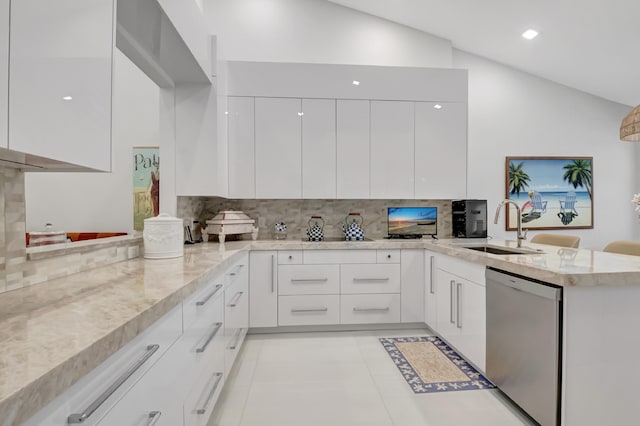 kitchen with lofted ceiling, a peninsula, a sink, stainless steel dishwasher, and modern cabinets