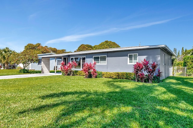 ranch-style home with a front yard, fence, and stucco siding