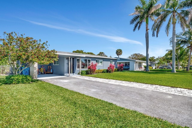 ranch-style home featuring driveway and a front lawn