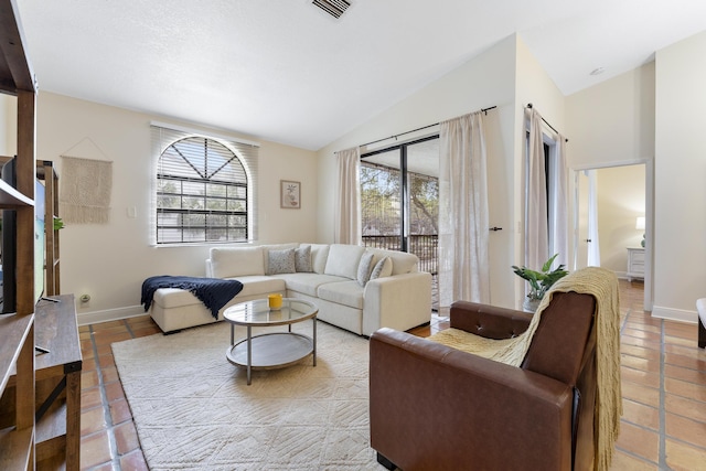 tiled living area featuring baseboards, visible vents, and vaulted ceiling