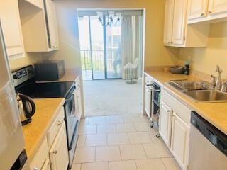 kitchen featuring a sink, appliances with stainless steel finishes, white cabinets, light countertops, and light tile patterned floors