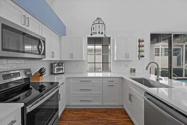 kitchen featuring stainless steel appliances, a sink, light countertops, and white cabinets