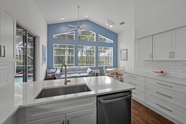 kitchen featuring a sink, tasteful backsplash, light countertops, and stainless steel dishwasher