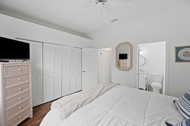 bedroom featuring dark wood-style floors, visible vents, connected bathroom, and a ceiling fan