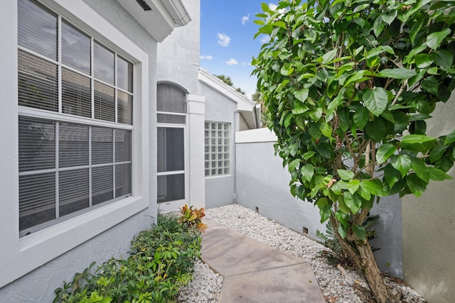 doorway to property with fence and stucco siding