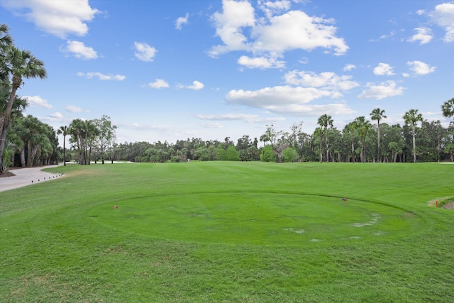 view of property's community featuring golf course view and a yard