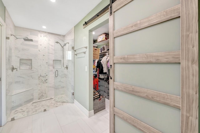 full bath featuring a spacious closet, recessed lighting, a shower stall, and baseboards
