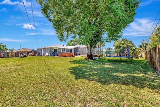 view of yard with a trampoline and a fenced backyard