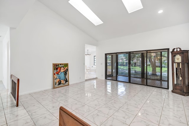 interior space featuring a skylight, baseboards, marble finish floor, high vaulted ceiling, and a notable chandelier