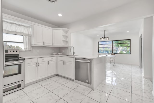 kitchen with marble finish floor, stainless steel appliances, light countertops, a sink, and a peninsula