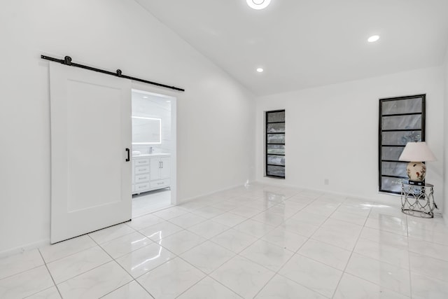 empty room with light tile patterned floors, a barn door, vaulted ceiling, and recessed lighting