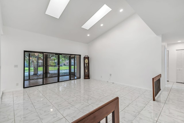 spare room with a skylight, baseboards, marble finish floor, high vaulted ceiling, and recessed lighting