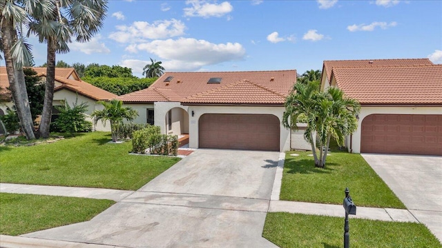 mediterranean / spanish-style house with stucco siding, a front lawn, concrete driveway, an attached garage, and a tiled roof