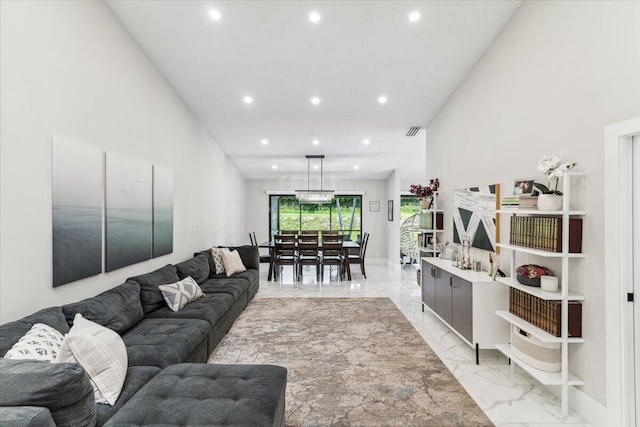 living room featuring recessed lighting, visible vents, marble finish floor, and a towering ceiling