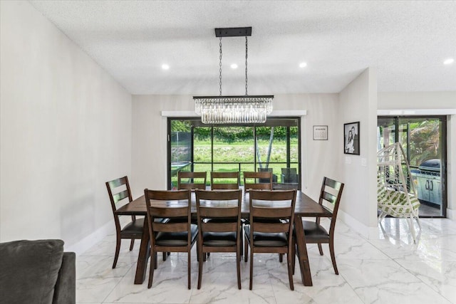 dining space featuring baseboards, a textured ceiling, and marble finish floor
