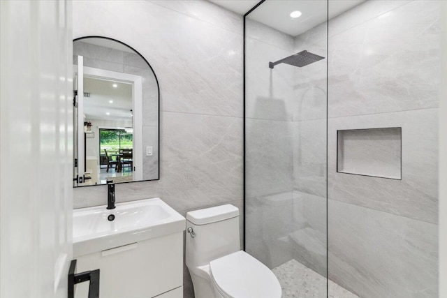 bathroom with walk in shower, toilet, recessed lighting, tile walls, and a sink