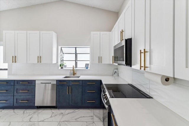 kitchen with lofted ceiling, a sink, stainless steel appliances, white cabinets, and blue cabinets