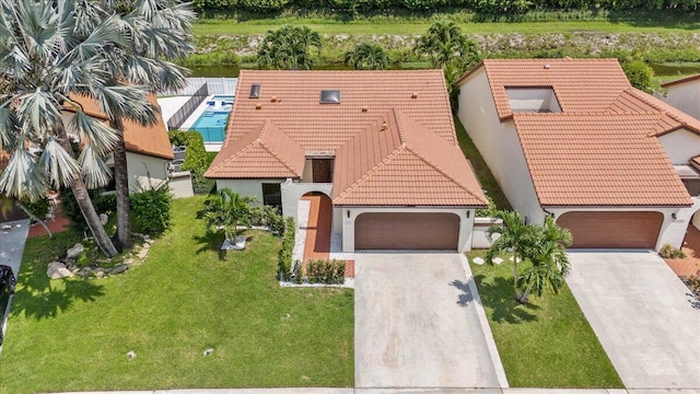 view of front of home with a front lawn, a tile roof, and a garage