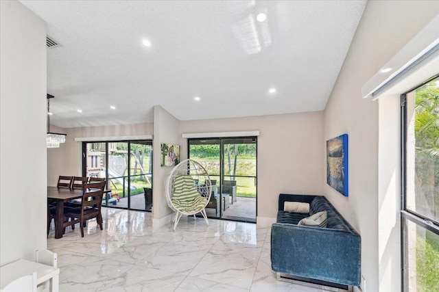living room featuring recessed lighting, marble finish floor, a textured ceiling, and visible vents