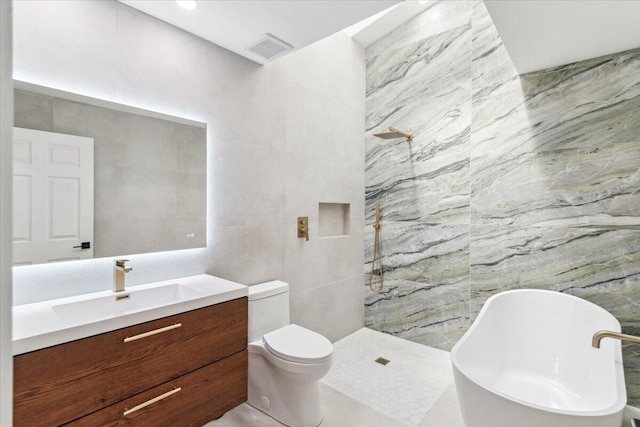 full bathroom featuring vanity, tile walls, walk in shower, and a freestanding bath