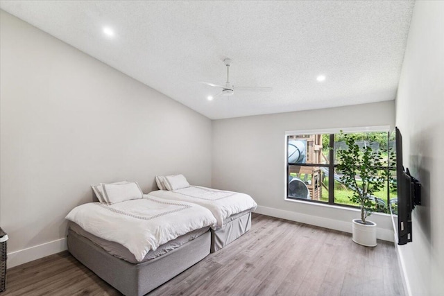 bedroom with ceiling fan, baseboards, recessed lighting, wood finished floors, and a textured ceiling