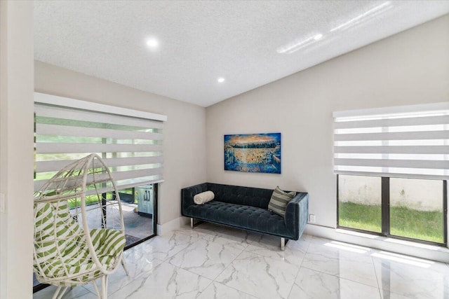 living area featuring baseboards, lofted ceiling, recessed lighting, marble finish floor, and a textured ceiling
