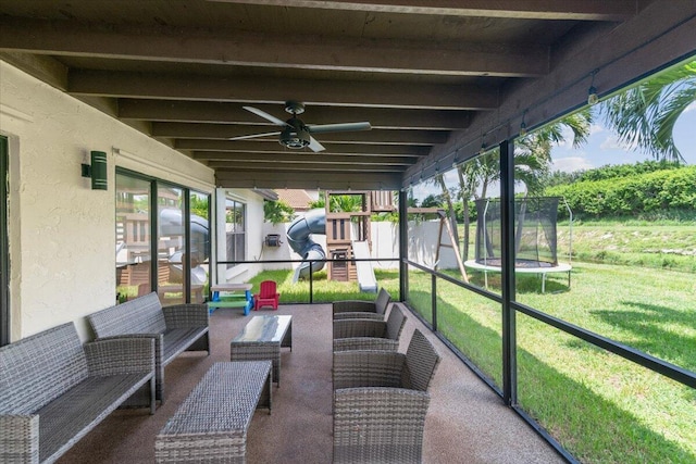 sunroom featuring beamed ceiling and ceiling fan