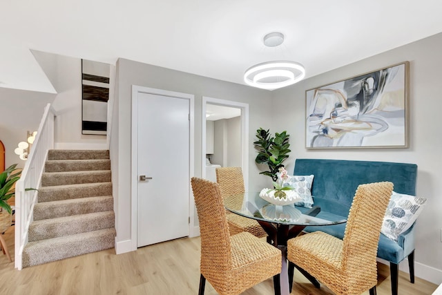 dining area featuring wood finished floors, baseboards, and stairs