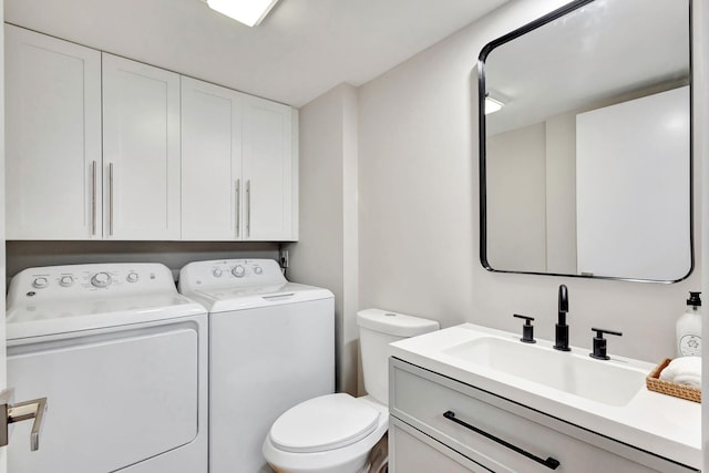 half bathroom with toilet, separate washer and dryer, and vanity