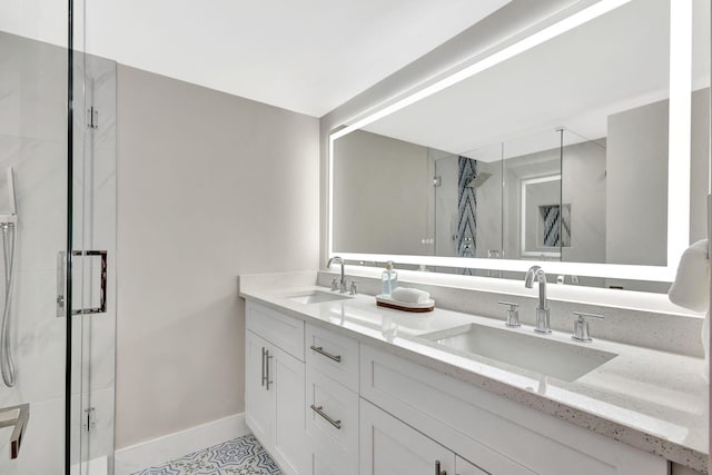 bathroom featuring double vanity, a shower stall, and a sink