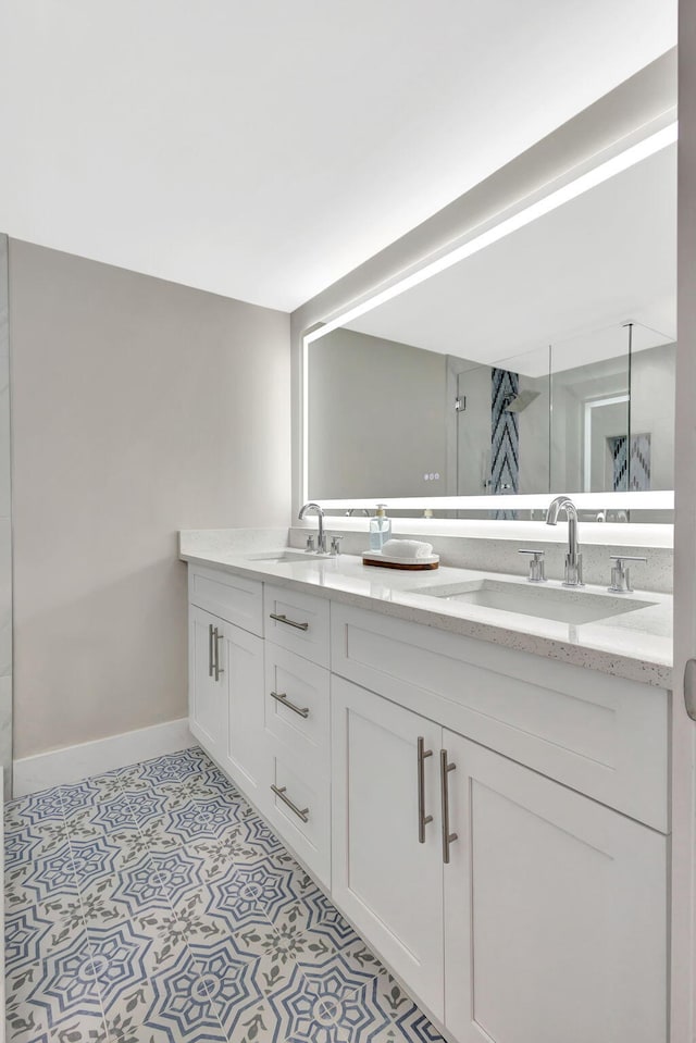 bathroom featuring tile patterned floors, a sink, baseboards, and double vanity