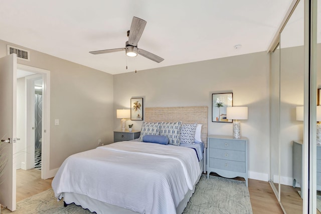 bedroom featuring visible vents, ceiling fan, light wood-style flooring, and baseboards