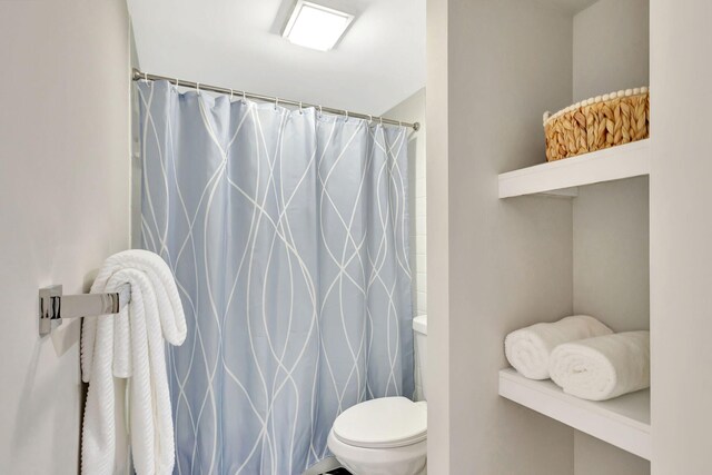 bathroom with toilet and curtained shower