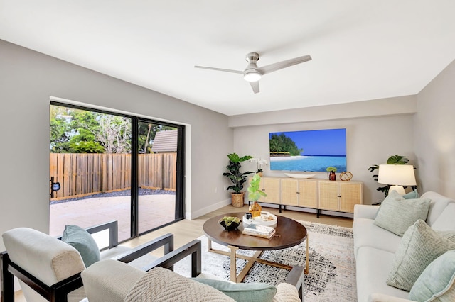 living area with a ceiling fan, baseboards, baseboard heating, and wood finished floors