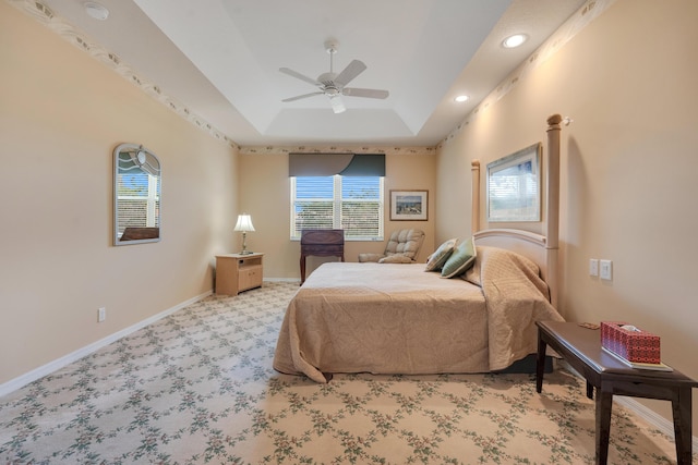 bedroom featuring recessed lighting, light carpet, a ceiling fan, baseboards, and a tray ceiling